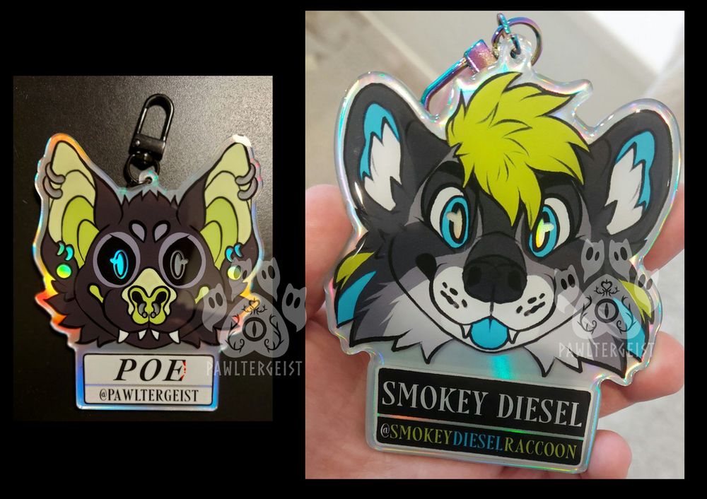 Acrylic badges of two different characters - the left one is a black, green and grey bat with piercings. The right one is a black, grey, green and blue raccoon.