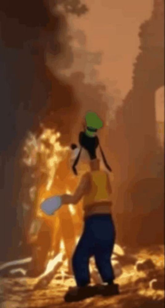 goofy is standing in front of a fire holding a bucket