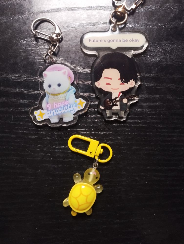 Llavero de un Sylvanian que dice 'tengo ansiedad' en inglés, llavero de Yoongi de BTS que pone 'Future's gonna be okay' y uno de una tortuguita de plástico amarilla brillante.