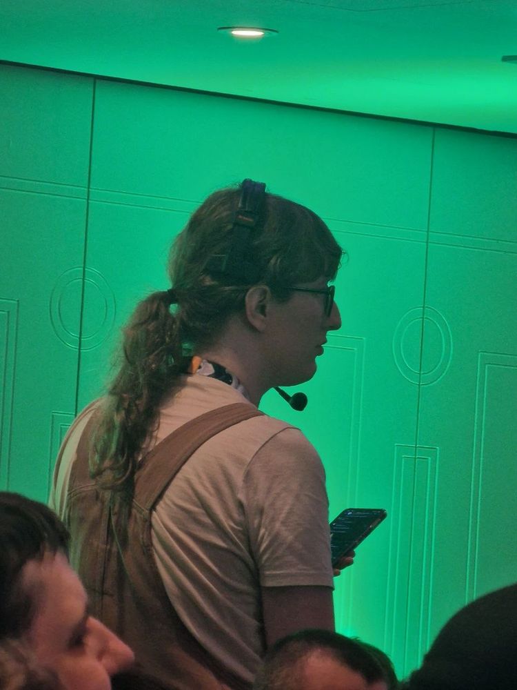 Picture from my backside showing me wearing a headset with microphone. I'm holding a phone in my hand