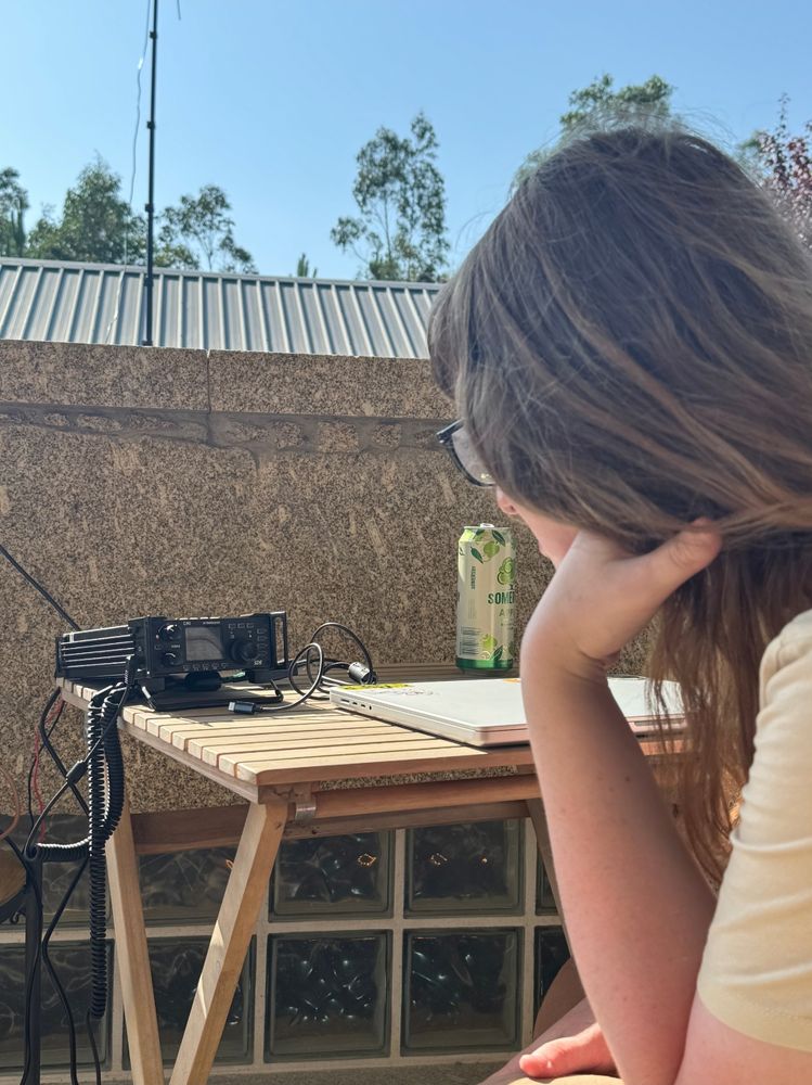 Picture of me facing the radio, on the table alongside it is a laptop and a drink. Its bright and sunny out
