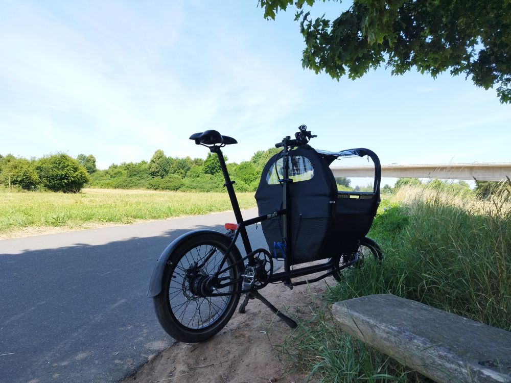Muli Lastenrad steht im Schatten an der Pausenbank