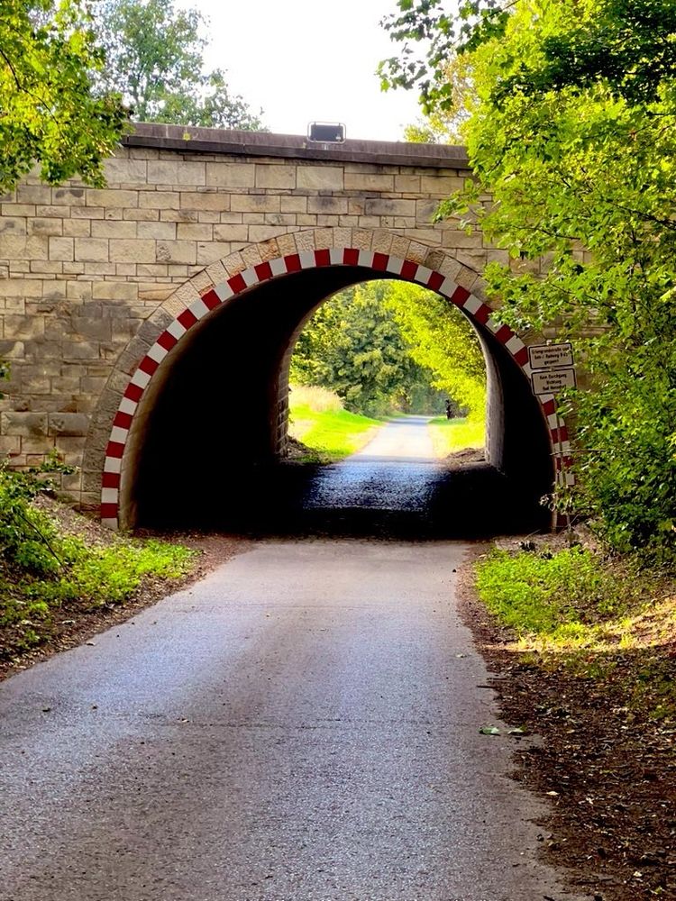 Zu sehe ist eine Straße, eine Gewölbebrücke und im Hintergrund siehe nächstes Bild 