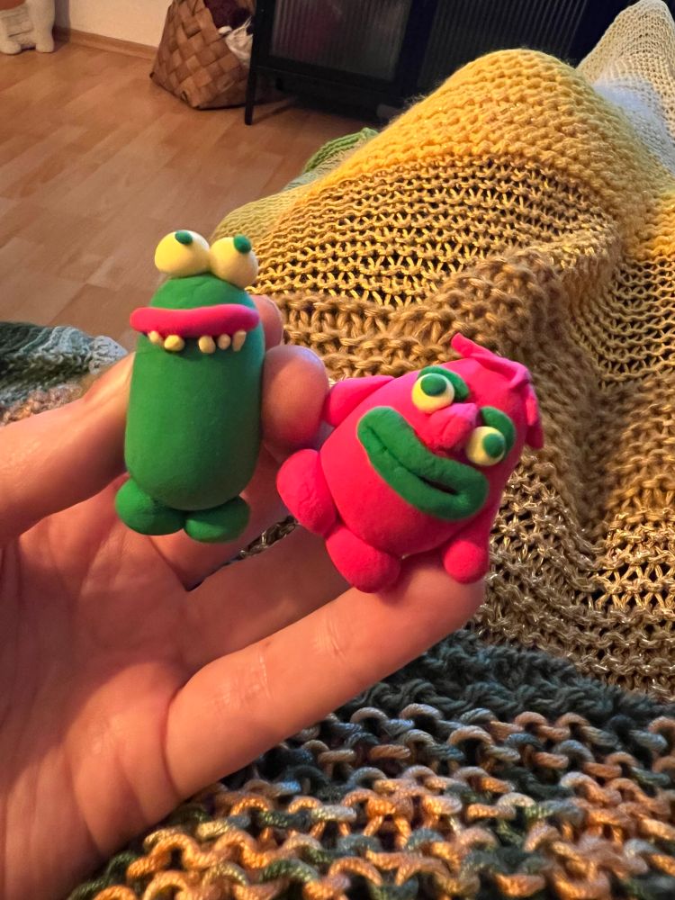 Zwei kleine bunte Monster aus Knete. 