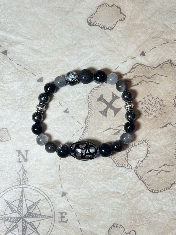 A beaded bracelet inspired by Blackbeard from Our Flag Means Death. Made with grey and black beads of different shades and textures.