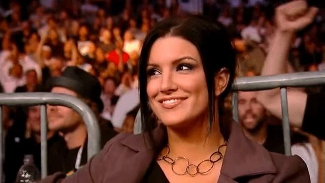 a woman is smiling while sitting in the stands of a stadium .