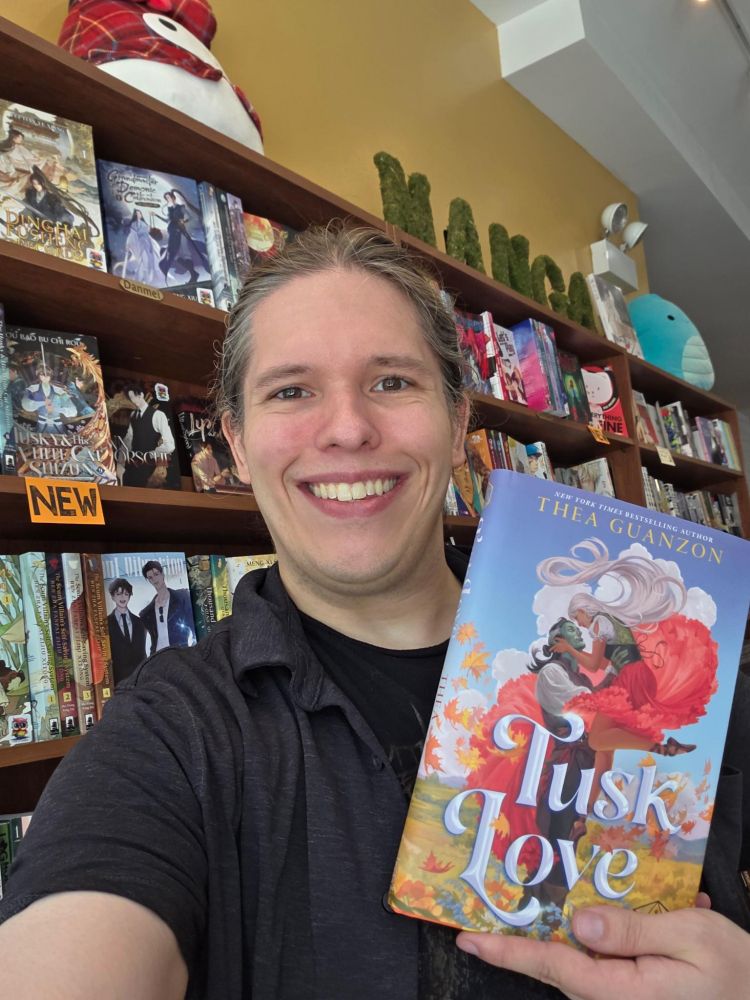 Daniel at Goblin Market holding the book Tusk Love 