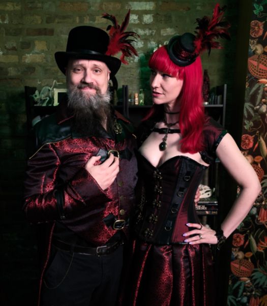 Baron and Baroness Winnowbane at Fallen London: Ouroboros -- a man and woman in ornate red and black costumes