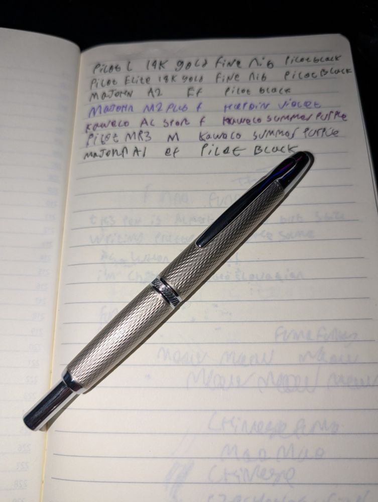 Majohn A1 fountain pen on a notebook page with several lines of pen tests