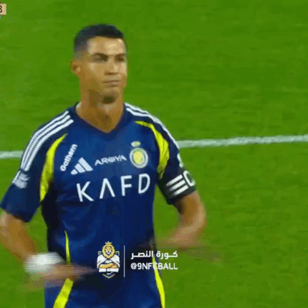 a soccer player wearing a kafd jersey stands on a field