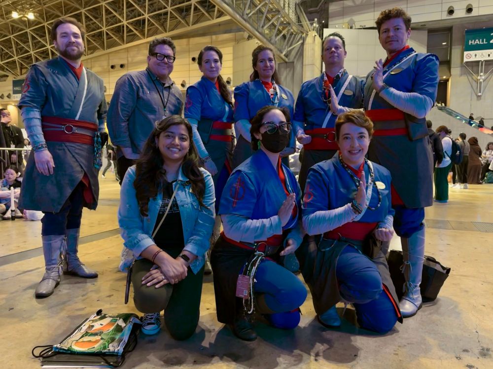 Seven saja and two guests stand in a large event space