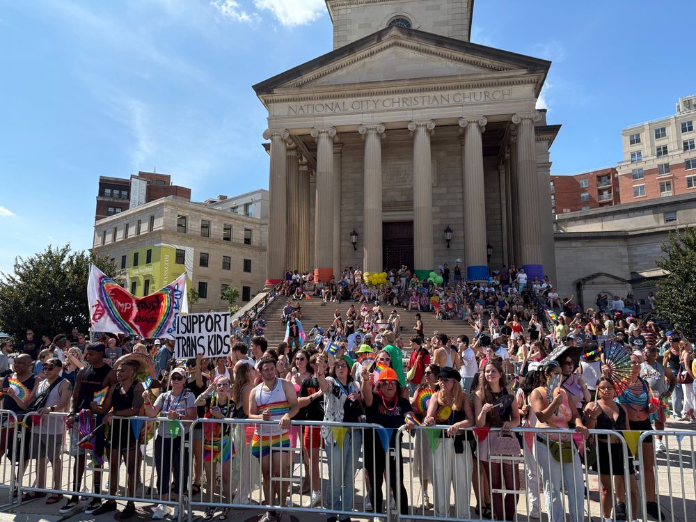 A crowd at Capital Pride in front of a church