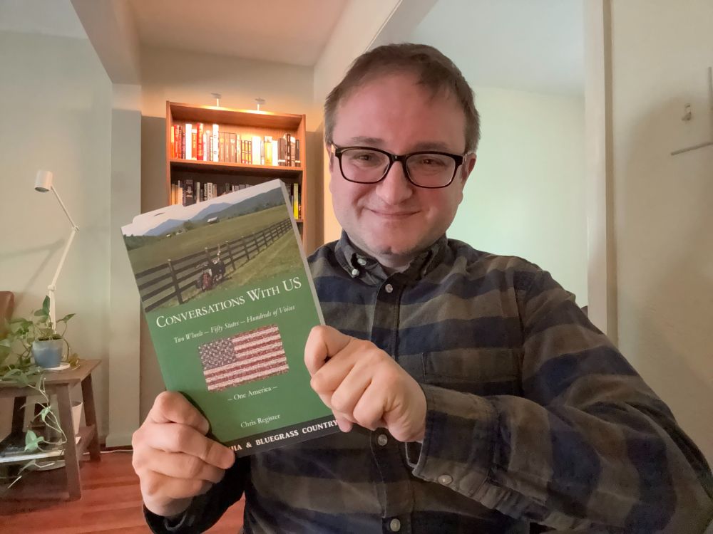 Michael holding a copy of the book "Conversations with US: Appalachia & Bluegrass Country"