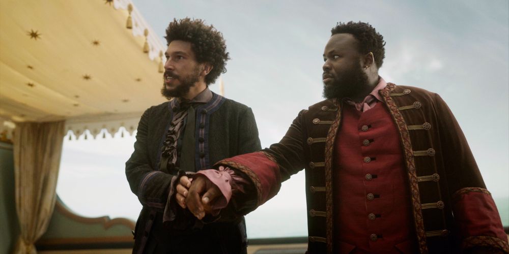 Frenchie and Olu from OFMD wearing fancy suits as they impersonate Prince Azi and his viceroy