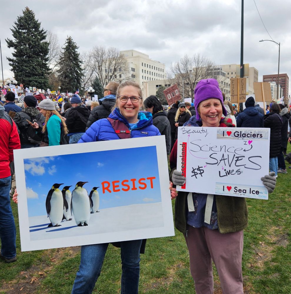 Penguins resist sign. Science saves lives sign. 