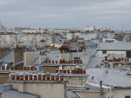 Des toits de Paris dans une lumière de matin d'été gris.