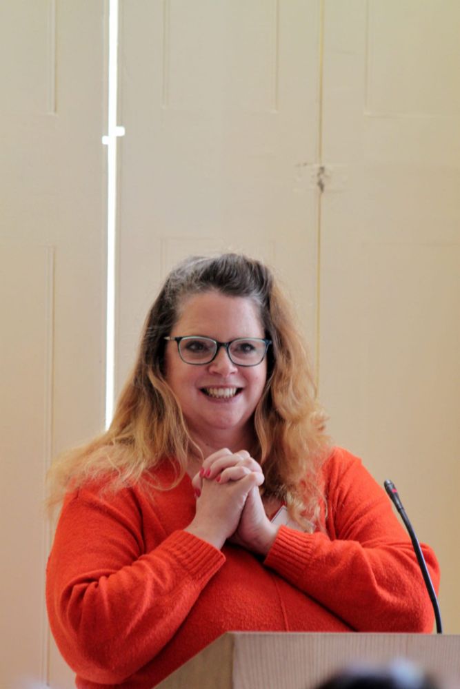 A woman clasping her hands 