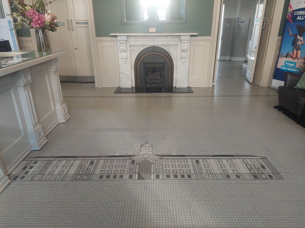 Tiled pattern of a long white building built into a floor