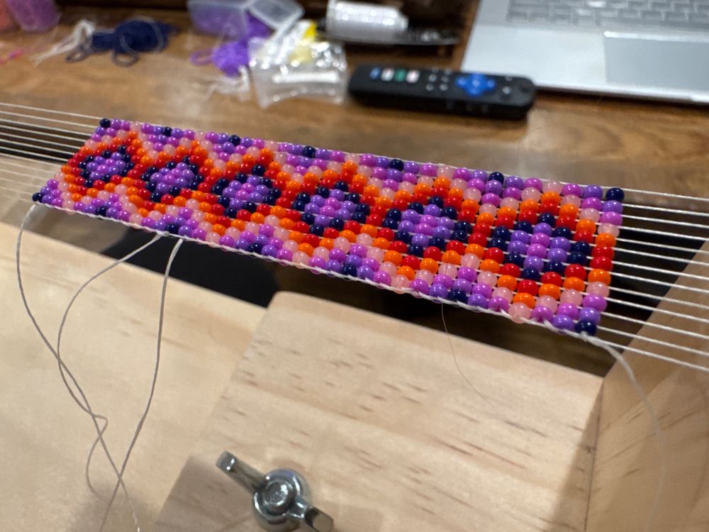 A longer sequence of colorful beads on a loom