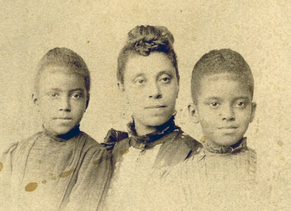 Portrait of an elegant woman flanked by two young daughters.