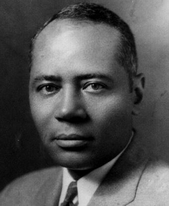 Close up of a man’s face, he’s gazing directly at the viewer. 