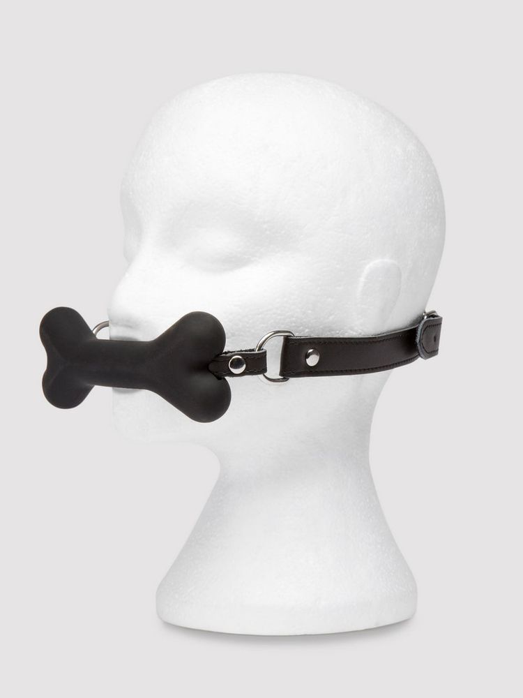 a white Styrofoam mannequin head wearing a black silicone bone gag at 3/4s angle