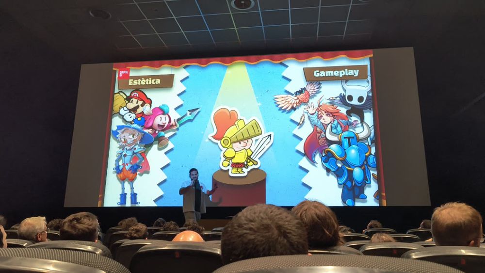 Fotografía de la presentación de "Un Sant Jordi de Paper", mostrando al protagonista en medio de la pantalla, con las referencias estéticas y de gameplay en las que se ha basado el juego.