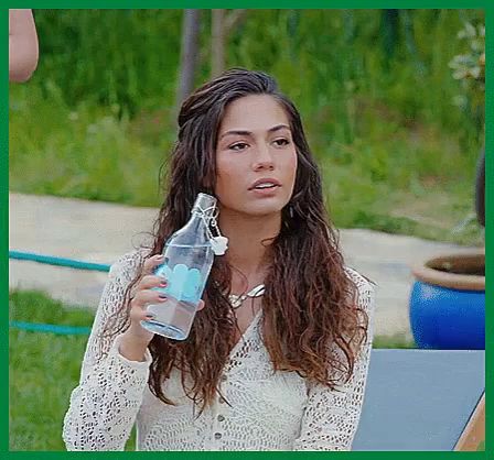 a woman in a white lace top is holding a clear bottle of water