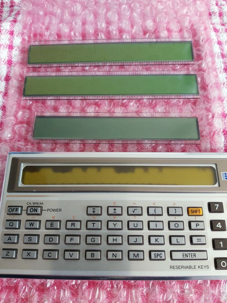 Photo of three replacement LCD panels and a PC-1211 showing LCD degradation.