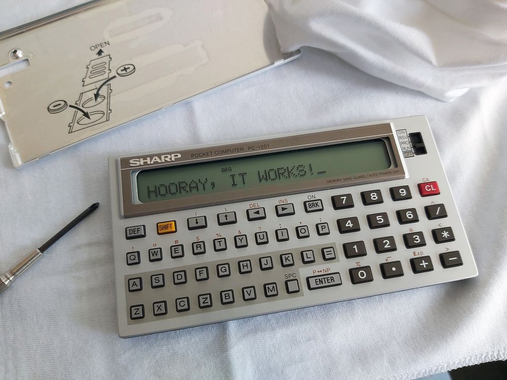 Photo of a Sharp PC-1251 with the replacement LCD installed. The screen of the PC-1251 reads "HOORAY, IT WORKS!"