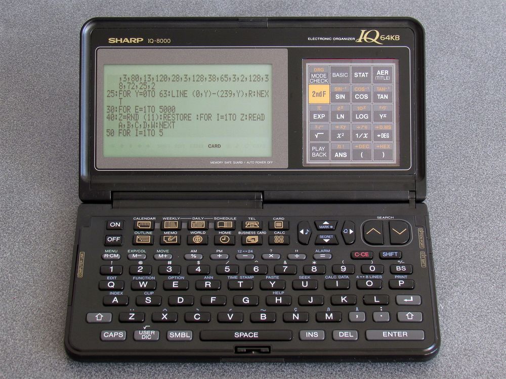 Photo showing an IQ-8000 electronic organiser editing a BASIC program in a small font. The BASIC program listing fills the screen (40x8 characters) instead of the usual 16x8 region.