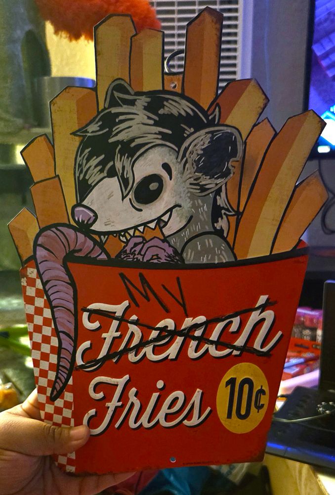 A picture of a metal sign in the shape of french fries, with a possum in the fry container eating fries and the word 'french' crossed off for the phrase "my fries" on the box container

Made with paint markers on a metal sign