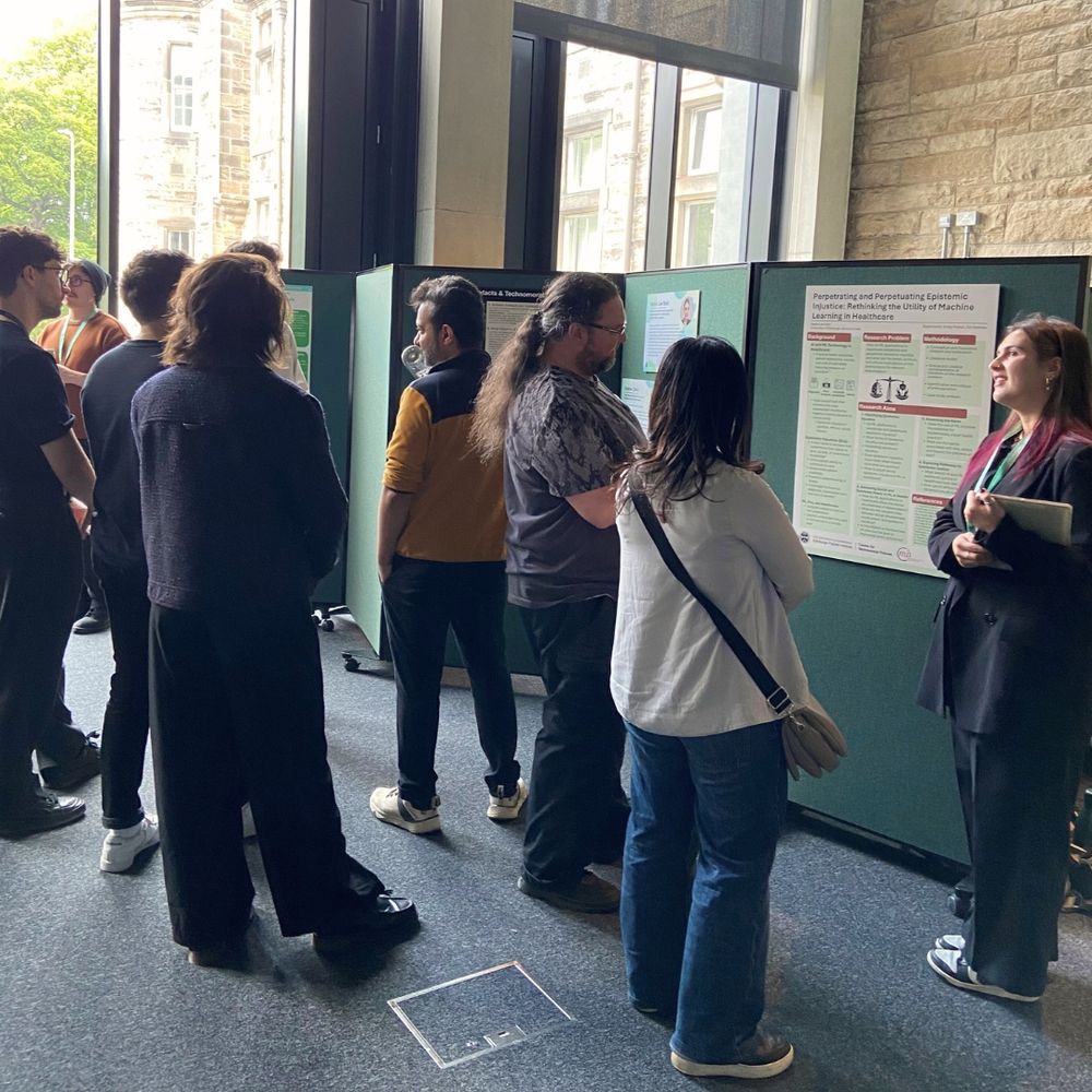 CTMF PhD Fellows are stood next to their research posters at the CTMF PhD Showcase. They are speaking with event attendees about their research.