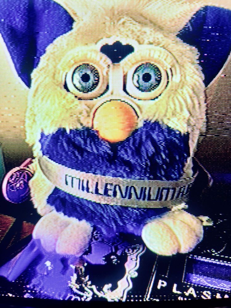 Furby with “Millennium Furby” banner, glitchy CRT old TV texture. 