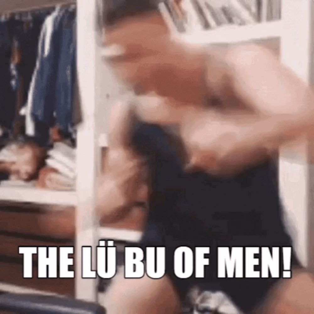 a shirtless man is fighting another shirtless man in a room with the words `` the lu bu of men '' written on it .