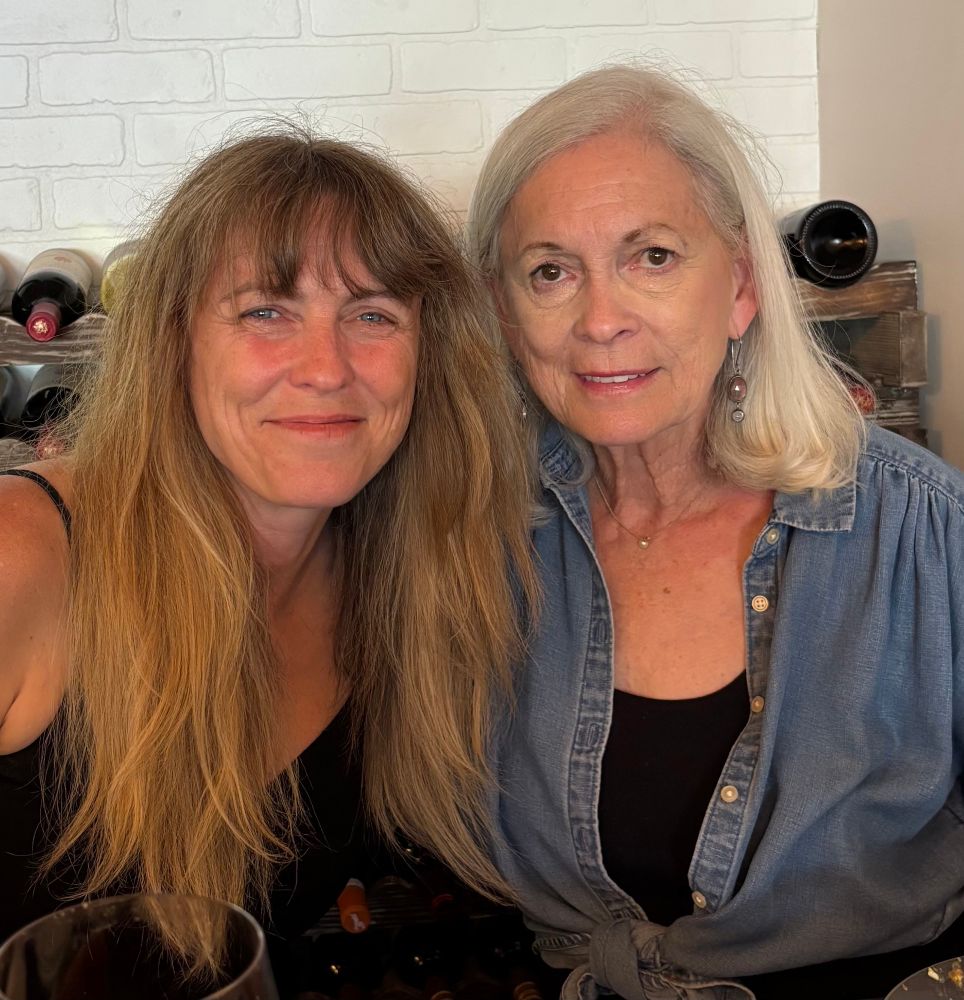 Two women smile into the camera 