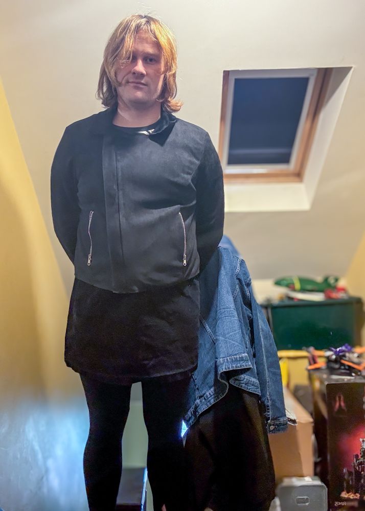 Giri in black jacket, black leggings, black skirt and black and white print tee 