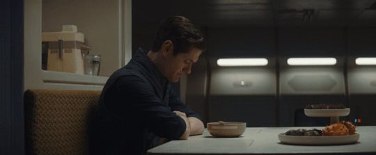 Syril Karn sitting at the kitchen table, staring at his cereal, contemplating the emptiness of existence and the inevitability of death.