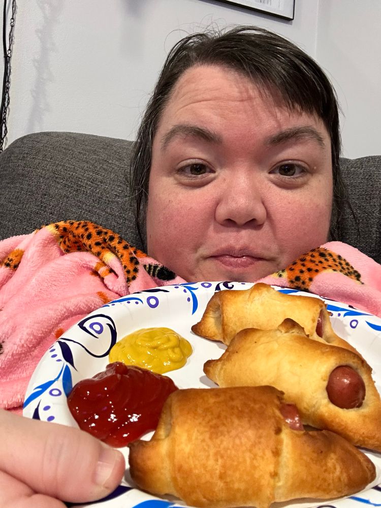 I’m holding a plate of of pigs in a blanket while under a blanket 