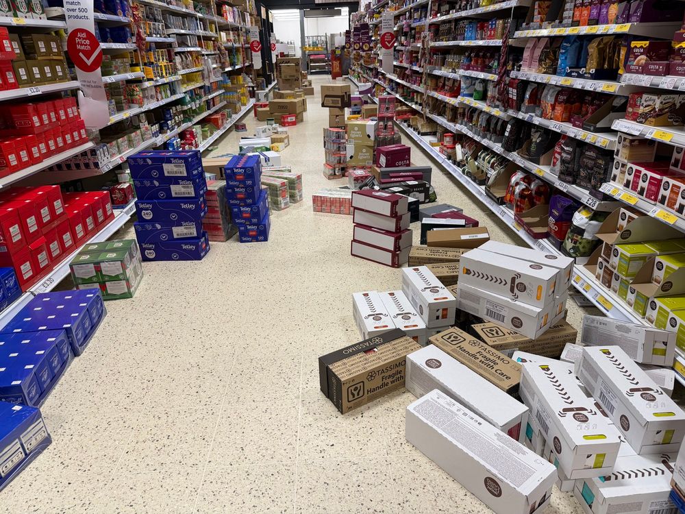 The tea and coffee aisle in a large Tesco supermarket, with boxes of stock scattered haphazardly in the walkway with no clearance for a trolley