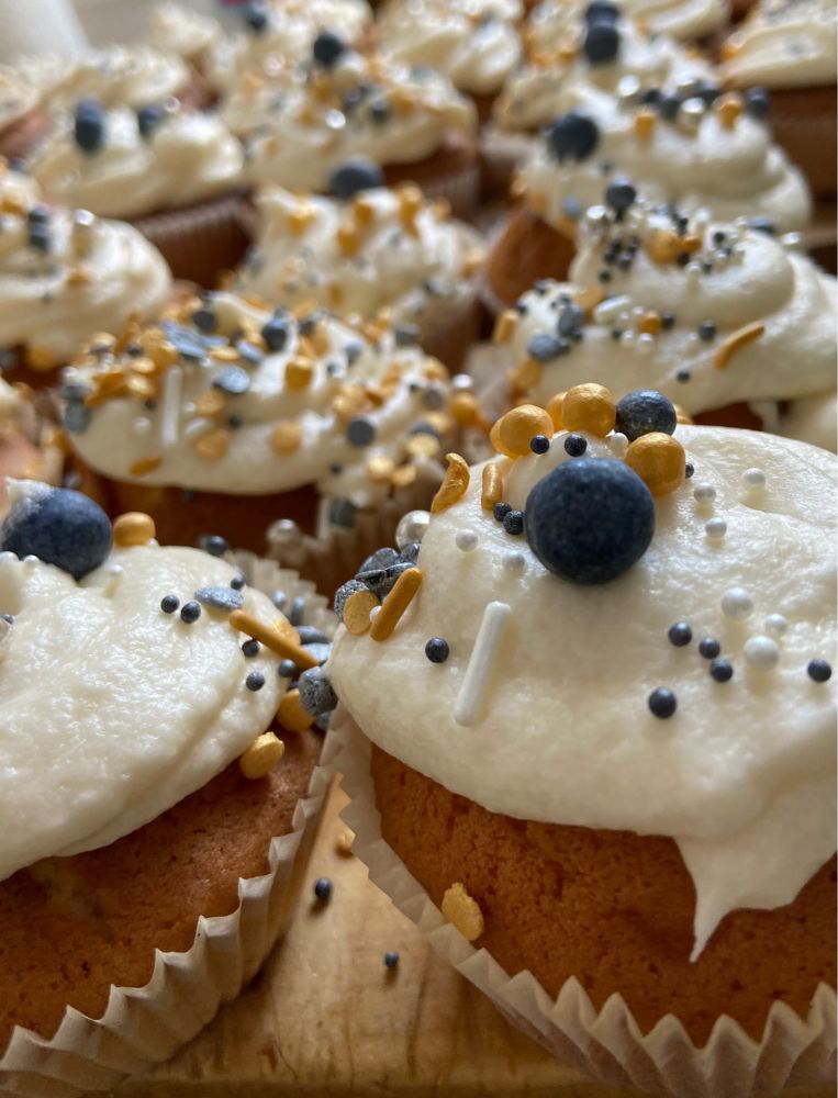 Jede Menge Cupcakes mit goldenen, weißen und schwarzen Streuseln drauf