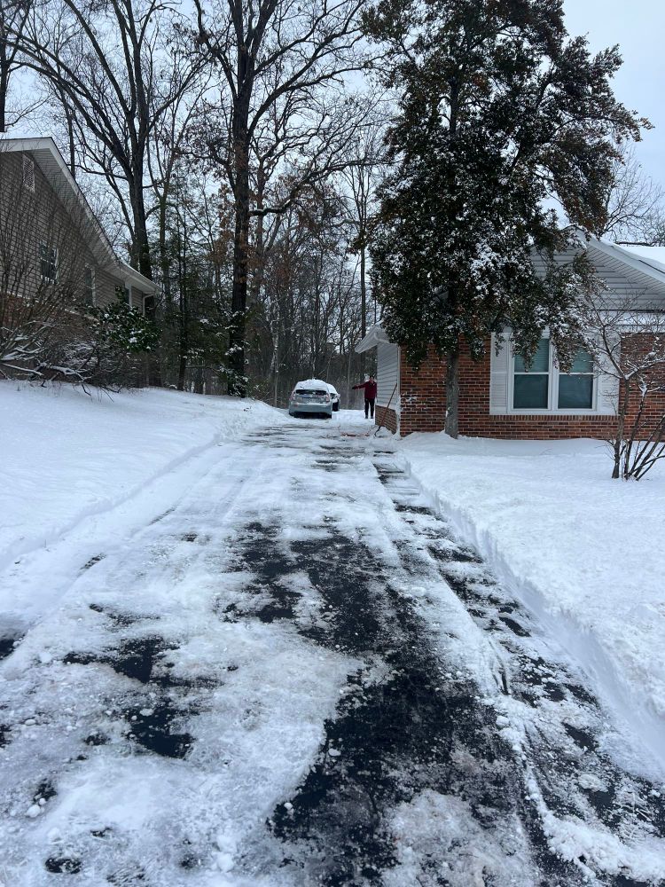 a pathed driveway through 8 inches of snow with a prius and a man at the end of it. 