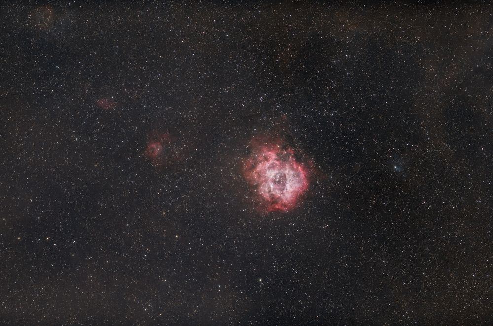 The Rosette Nebula, a red-pink emission nebula shot at 135mm focal length. It resembles a rosette, as the name suggests and is sometimes referred to as the Skull Nebula. 