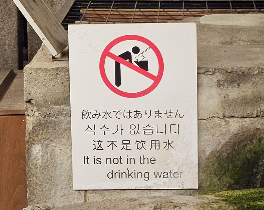 Sign from a Japanese shrine advising visitors to not drink the water, translated to English as a quite ominous "It is not in the drinking water".