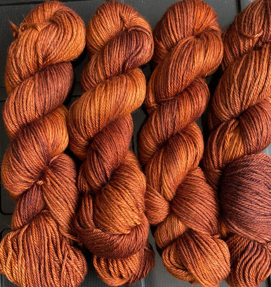 Hand-dyed skeins of alpaca worsted in a rich colour called Terra Cotta.