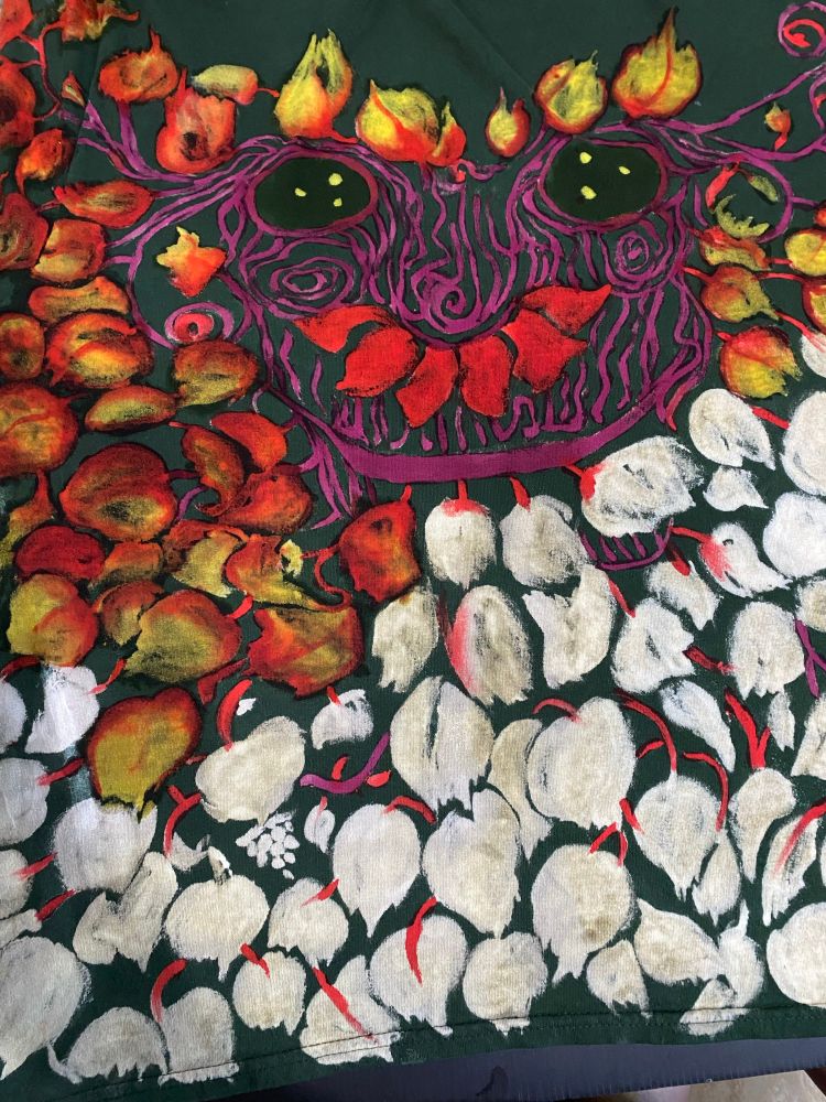 A larger view of the face of a blackberry spirit, showing more of the unpainted design of leaves, vines and berries.