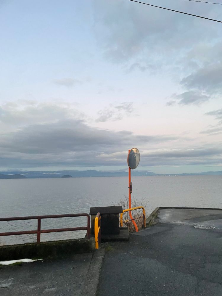 琵琶湖岸の道に立っているオレンジ色の反射鏡。