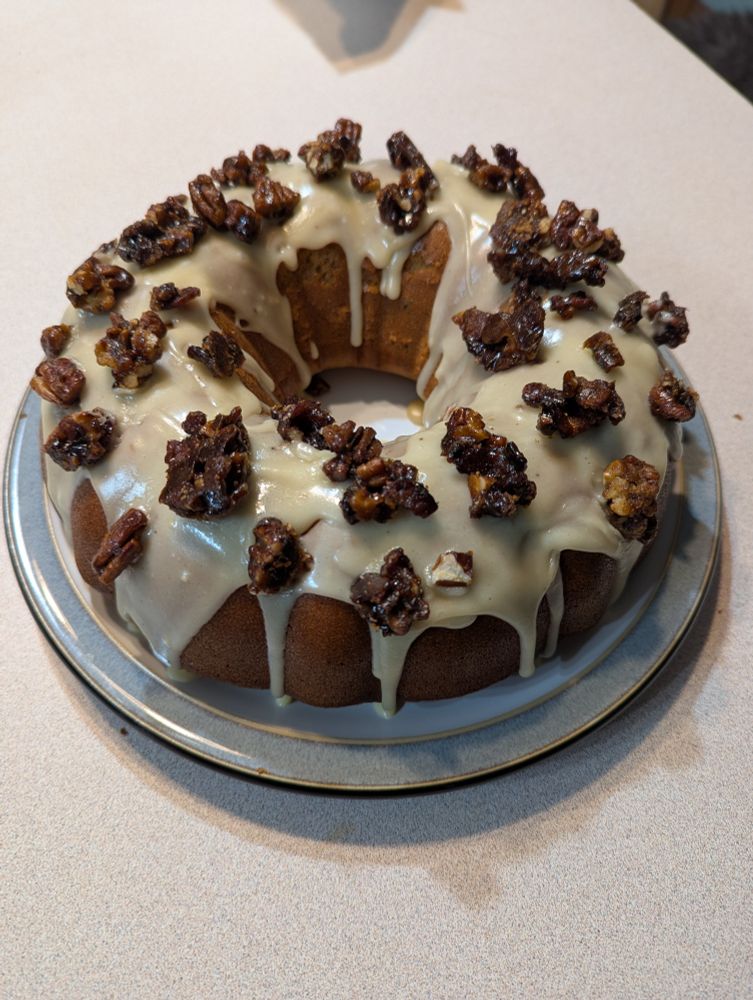 A Maple Bacon Bundt cake topped with candied pecans and bacon