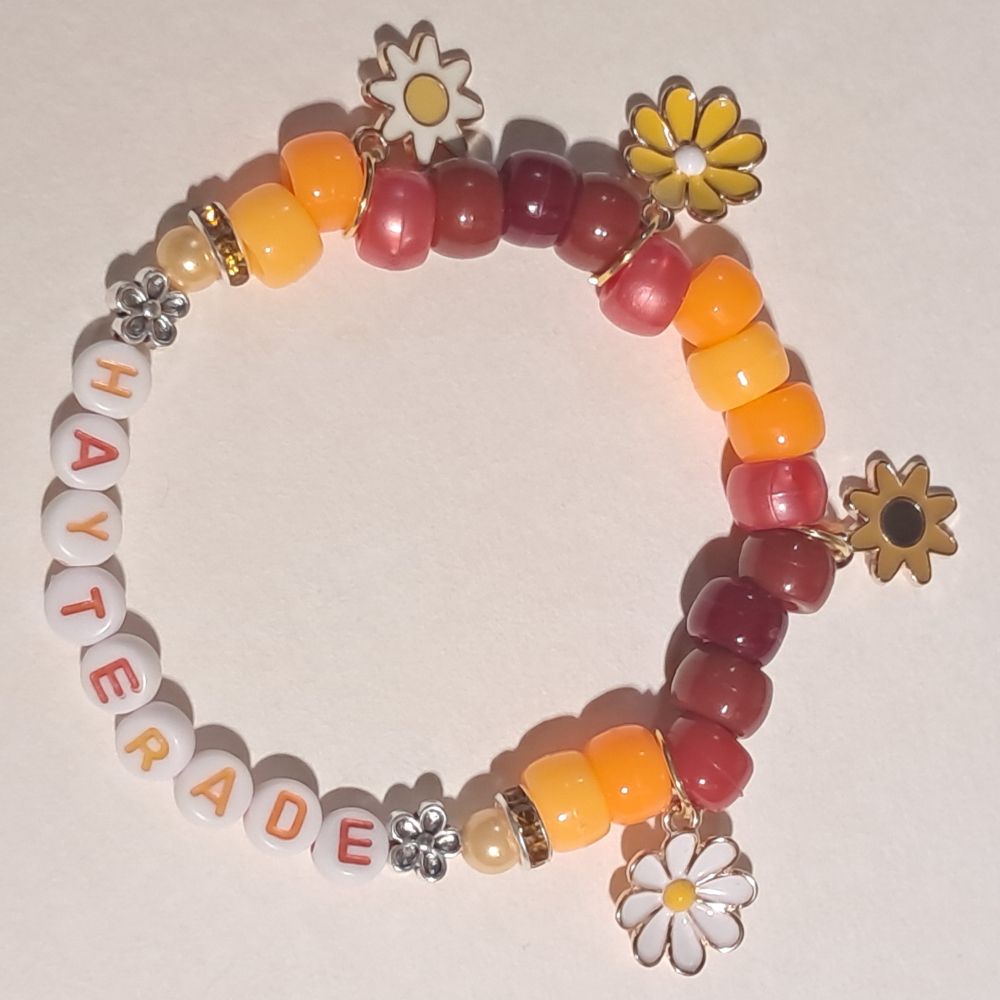 orange and red/brown 'hayterade' bracelet with several flower charms
