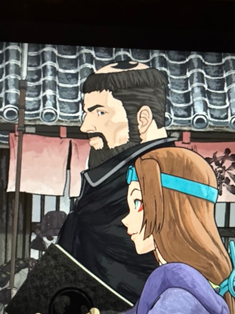 Feudal Japan Bruce Wayne, dressed in black monks’ robes with a tonsure, except in the middle of the tonsure is shaved the Bat Symbol. I will never be high enough to think up an idea like this. Also there’s a shorter brown-haired woman next to him, that’s Catwoman